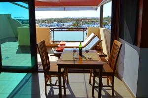 a table and chairs on a balcony with a view at Crystalsuite. Beautiful penthouse with sea views in Corralejo