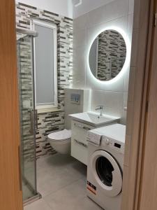 uma casa de banho com um WC e uma máquina de lavar roupa. em APARTS FOR YOU PREMIUM IX NOWE TORPO em Toruń