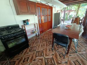 uma cozinha com uma mesa e um fogão em Casa Agua Bacalar / Naajil Ha em Bacalar