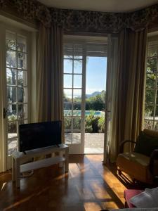 un soggiorno con TV e ampia finestra di Villa Sofia a San Felice del Benaco