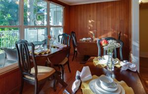 una sala da pranzo con tavolo, sedie e finestra di SeaGlass Inn Bed and Breakfast a Melbourne Beach