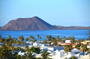 a view of a resort with a mountain in the background at Crystalsuite. Beautiful penthouse with sea views in Corralejo