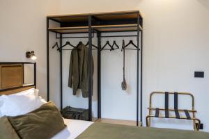 ein Schlafzimmer mit einem Bett und einem Schrank mit einem Kleiderständer in der Unterkunft Bohémien Boutique Guesthouse in Cefalú