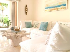 a living room with two white couches and a table at Beachfront Breathtaking Views Puerto Aventuras in Puerto Aventuras