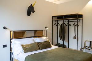 a bedroom with a bed and a coat rack at Bohémien Boutique Guesthouse in Cefalù