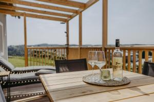a bottle of wine and a glass on a wooden table at WEIN DOMIZIL Zieger in Neuhaus am Klausenbach