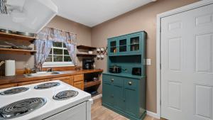 uma cozinha com um fogão branco e um armário azul em Cozy 2b/1ba close to everything em Hattiesburg