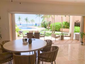a dining room with a table and chairs and a patio at Beachfront Breathtaking Views Puerto Aventuras in Puerto Aventuras