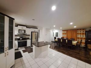 a kitchen and living room with a table and chairs at Auberge Motel LA RÉFÉRENCE in Trois-Rivières