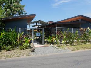 un edificio con recinto e piante di fronte ad esso di Raya a Matapalo