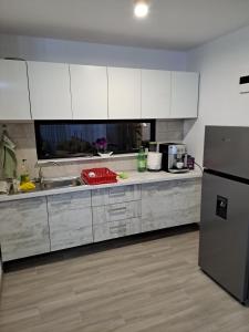 een keuken met witte kasten en een roestvrijstalen koelkast bij Casa Mara 