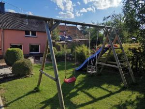a swing set in the yard of a house at Ferienwohnung am Wasserfall in Nohn
