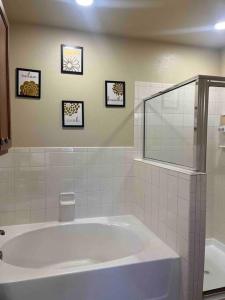 a bathroom with a large tub and three pictures on the wall at Hill Country Hiatus! in Austin