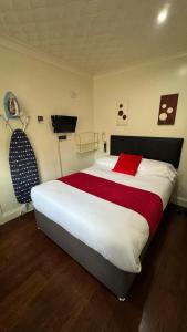 a bedroom with a large bed with a red pillow at The Railway Sleeper Lodge in Colchester