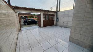 an empty patio with a car parked in a garage at Balneário Jussara in Mongaguá