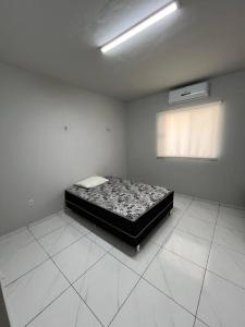 Un dormitorio con una cama en una habitación con ventana. en Darocha Salinas, en Salinópolis 6 fotos más