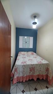a bedroom with a bed and a blue wall at Balneário Jussara in Mongaguá