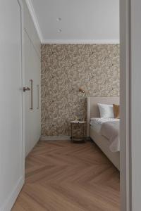 a bedroom with a bed and a wall at Puodžių 5 - Self check in, , City center in Klaipėda