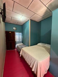 a bedroom with two beds and a red carpet at Hotel Gusto Bueno in Coxen Hole