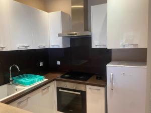 a kitchen with white cabinets and a sink and a stove at Appartement a tunis in Tunis