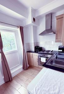 a kitchen with a sink and a stove and a window at London Chelsea 2 People Balcony Best Location in London