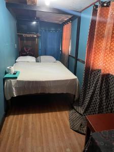 Coxen Hole的住宿－Hotel Gusto Bueno，一间卧室设有一张大床,铺有木地板