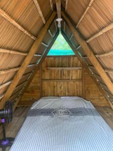 a bed in a wooden room with a roof at Camping Babsita in Tuba Creek