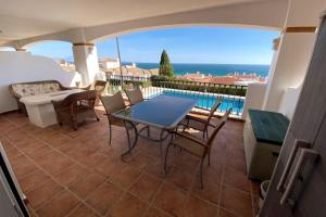 eine Terrasse mit Tisch und Stühlen und Blick auf das Meer in der Unterkunft Terrazas de Guadalupe - Sea view in Manilva
