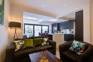 ein Wohnzimmer mit 2 Sofas und einem Tisch in der Unterkunft Exquisite 5-Bedroom in London and Essex - Sleeps 10 with Free Parking in Romford