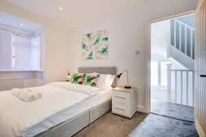 ein weißes Schlafzimmer mit einem Bett und einer Treppe in der Unterkunft Exquisite 5-Bedroom in London and Essex - Sleeps 10 with Free Parking in Romford