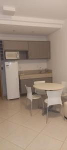 a kitchen with a table and chairs and a refrigerator at Condominio Barretos Thermas Park apto 312 in Barretos