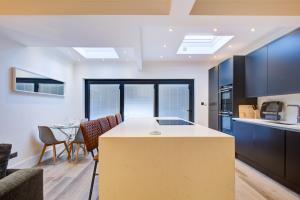 cocina y sala de estar con mesa y sillas en Exquisite 5-Bedroom in London and Essex - Sleeps 10 with Free Parking, en Romford