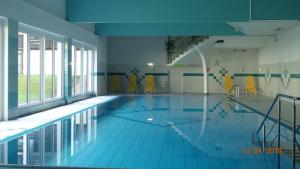 a large swimming pool with yellow chairs in a building at Grubhof in Sankt Martin bei Lofer