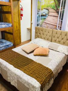 uma cama com duas almofadas num quarto em Sacavem Flat Hotel Navegantes em Navegantes