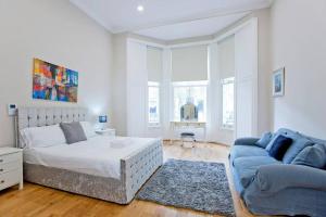biała sypialnia z łóżkiem i kanapą w obiekcie Outstanding 1 bed duplex w Londynie