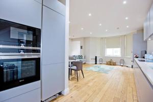 kuchnia z białymi urządzeniami i salon w obiekcie Outstanding 1 bed duplex w Londynie