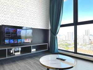 ein Wohnzimmer mit einem TV und einem Couchtisch in der Unterkunft Urban Pleasure Suites Central of GeorgeTown Jelutong in Jelutong