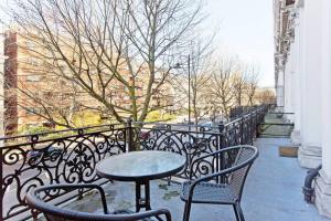 a patio with a table and chairs on a balcony at Beautiful 1bed with Balcony in London