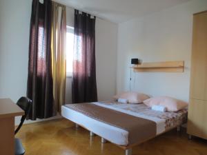 Un dormitorio con una cama con almohadas rosas y una ventana en Apartments Kovacic, en Omiš