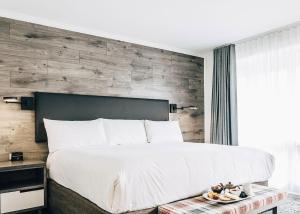 1 dormitorio con 1 cama grande y pared de madera en The Hotel on Pownal, en Charlottetown