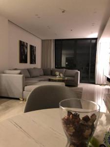 a living room with a couch and a table with a wine glass at Luxury 2-bedroom Apartment Abdoun tower in Amman