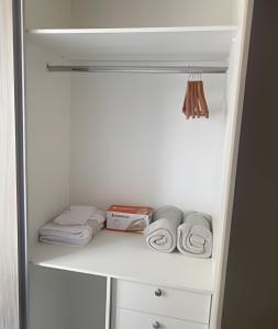 um frigorífico branco com algumas toalhas numa prateleira em Ap c/Garagem, Elevador, Cozinha Completa, Lava e Seca, Jr Catito em Brasília