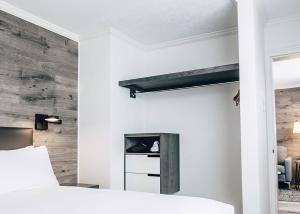 a bedroom with white walls and a fireplace at The Hotel on Pownal in Charlottetown