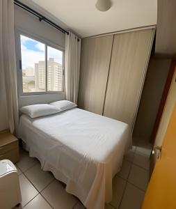 um quarto com uma cama e uma grande janela em Ap c/Garagem, Elevador, Cozinha Completa, Lava e Seca, Jr Catito em Brasília