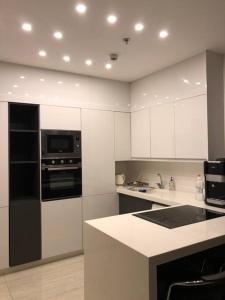 a kitchen with white cabinets and a black and white appliance at Luxury 2-bedroom Apartment Abdoun tower in Amman