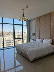 a bedroom with a large bed and a large window at Luxury 2-bedroom Apartment Abdoun tower in Amman