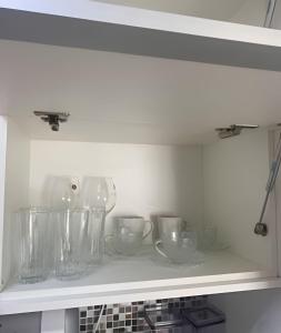 uma prateleira numa cozinha com taças e copos em Ap c/Garagem, Elevador, Cozinha Completa, Lava e Seca, Jr Catito em Brasília