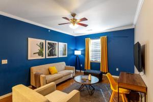 een woonkamer met blauwe muren en een plafondventilator bij Trendy Place to Stay in Downtown next to Convention Center in Dallas