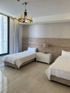 a bedroom with two beds and a chandelier at Luxury 2-bedroom Apartment Abdoun tower in Amman