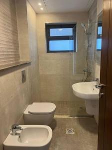 a bathroom with a toilet and a sink at Luxury 2-bedroom Apartment Abdoun tower in Amman